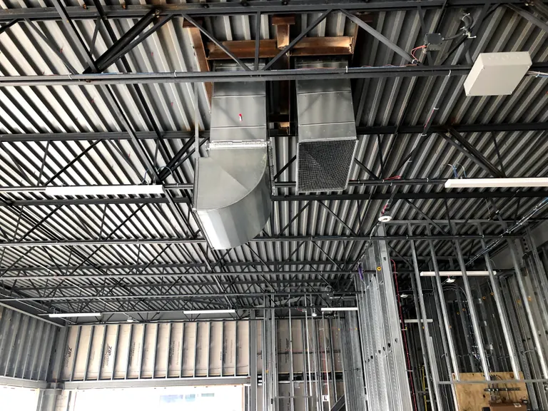 Metal ductwork beneath an exposed ceiling in a commercial interior.
